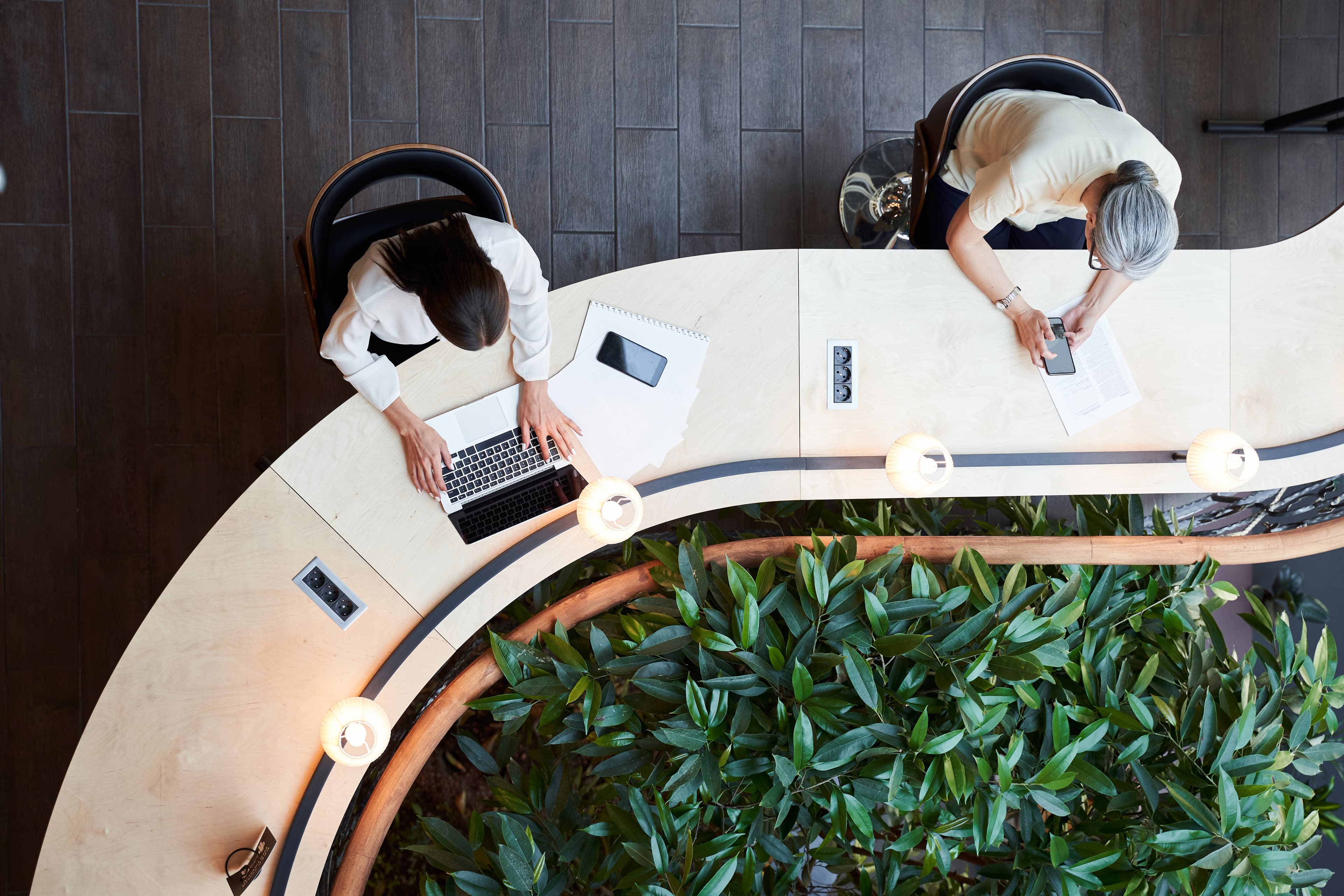 Overhead of two women working at a desk